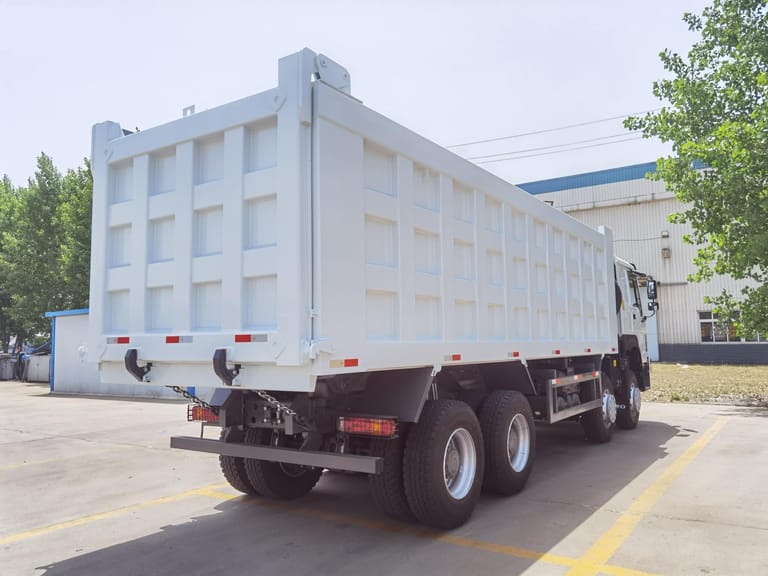 Rear 3/4 view of HOWO 380HP 8x4 dump truck highlighting the cargo bed, hydraulic lifting system, and stable 8x4 configuration for heavy-duty hauling