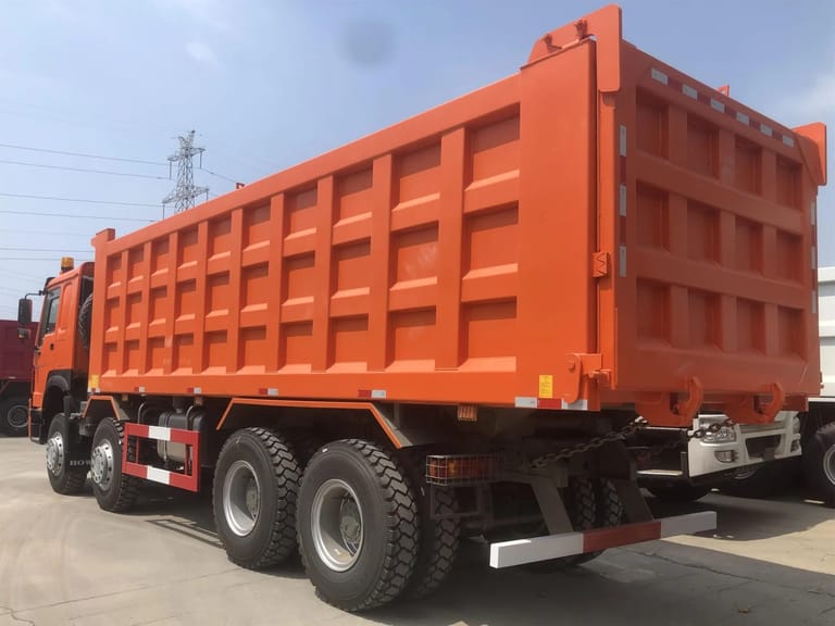 HOWO 400HP 8×4 dump truck rear three-quarter angle highlighting the tailgate, hydraulic lifting system, and rear axles HOWO 400HP 8×4 dump truck rear three-quarter angle highlighting the tailgate, hydraulic lifting system, and rear axles