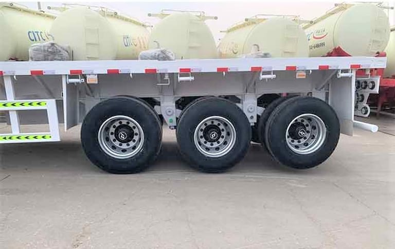 Close-up of tires on 60 Ton Flatbed Truck Trailer – showing heavy-duty tires, durable rims, and reinforced suspension for reliable high-capacity cargo transport. Close-up of tires on 60 Ton Flatbed Truck Trailer – showing heavy-duty tires, durable rims, and reinforced suspension for reliable high-capacity cargo transport.