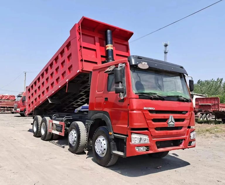 HOWO 420HP 8X4 dump truck front 3/4 view, high-roof cabin with ergonomic seats and air conditioning, optimized for long-haul construction work HOWO 420HP 8X4 dump truck front 3/4 view, high-roof cabin with ergonomic seats and air conditioning, optimized for long-haul construction work