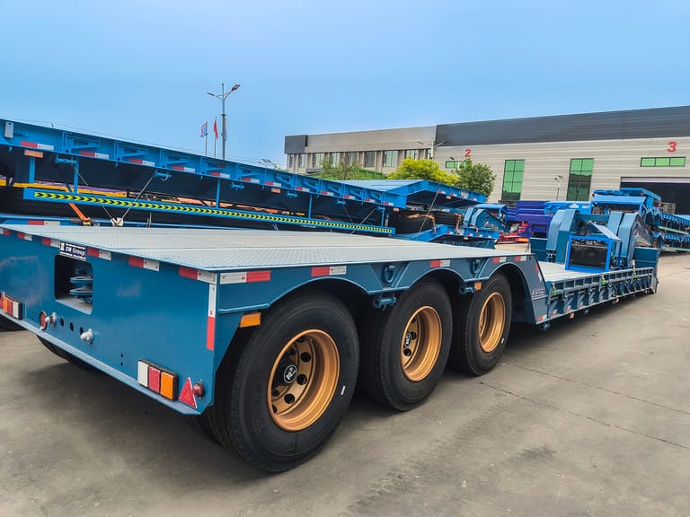 Close-up of 12R22.5 tubeless tires on 3 Axle 80 Ton RGN Lowbed Semi Trailer highlighting durability and heavy-load capability Close-up of 12R22.5 tubeless tires on 3 Axle 80 Ton RGN Lowbed Semi Trailer highlighting durability and heavy-load capability