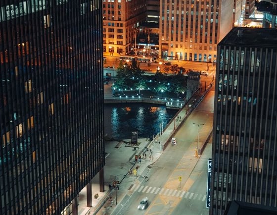 body of water between high rise buildings during night time