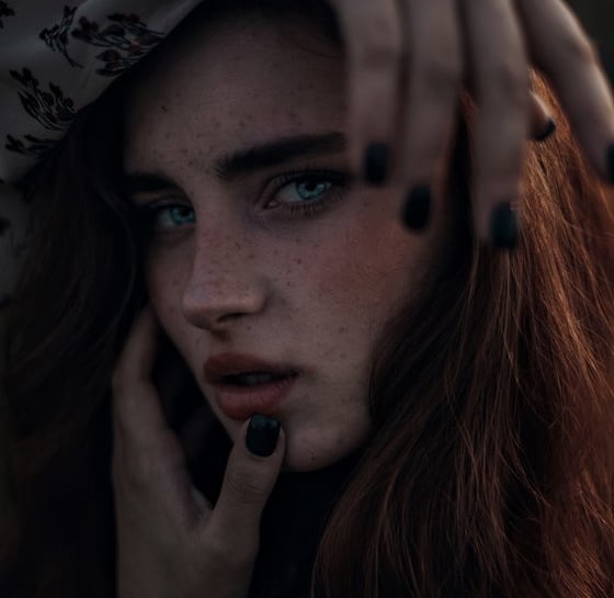 woman with brown hair wearing white and black floral hijab