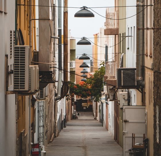 empty hallway between concrete buildings during daytime