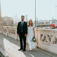 man in black suit standing beside woman in white wedding dress