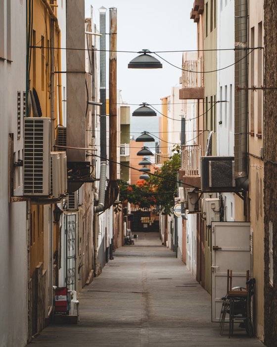 empty hallway between concrete buildings during daytime