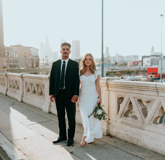 man in black suit standing beside woman in white wedding dress