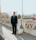 man in black suit standing beside woman in white wedding dress