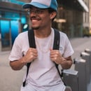 man in white crew neck t-shirt wearing blue cap and black sunglasses