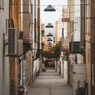 empty hallway between concrete buildings during daytime