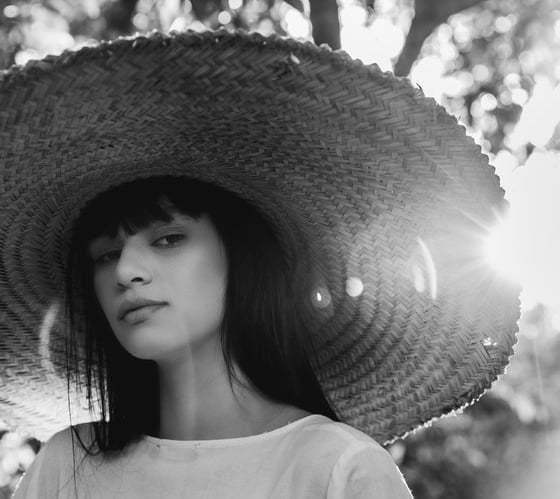 woman in white crew neck shirt wearing brown sun hat