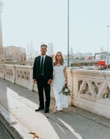 man in black suit standing beside woman in white wedding dress