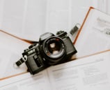 black nikon dslr camera on white printer paper