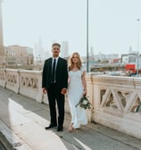 man in black suit standing beside woman in white wedding dress