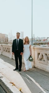 man in black suit standing beside woman in white wedding dress