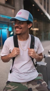 man in white crew neck t-shirt wearing blue cap and black sunglasses