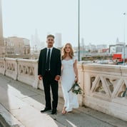 man in black suit standing beside woman in white wedding dress