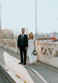 man in black suit standing beside woman in white wedding dress
