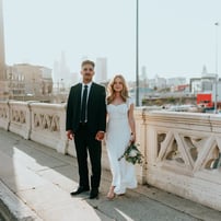 man in black suit standing beside woman in white wedding dress