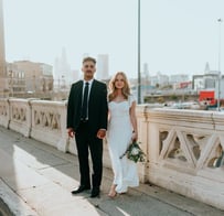 man in black suit standing beside woman in white wedding dress