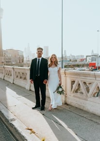 man in black suit standing beside woman in white wedding dress