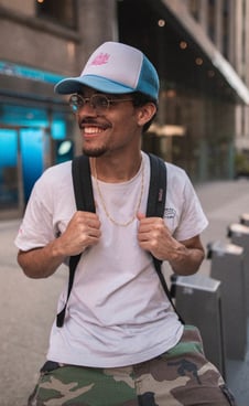 man in white crew neck t-shirt wearing blue cap and black sunglasses