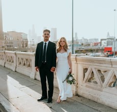 man in black suit standing beside woman in white wedding dress