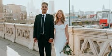 man in black suit standing beside woman in white wedding dress
