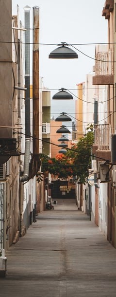 empty hallway between concrete buildings during daytime