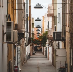 empty hallway between concrete buildings during daytime