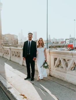 man in black suit standing beside woman in white wedding dress
