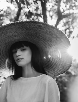 woman in white crew neck shirt wearing brown sun hat