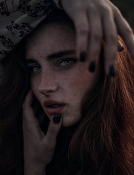 woman with brown hair wearing white and black floral hijab