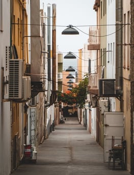 empty hallway between concrete buildings during daytime
