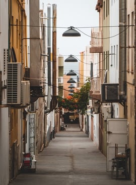 empty hallway between concrete buildings during daytime