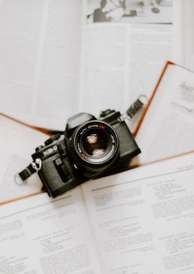 black nikon dslr camera on white printer paper