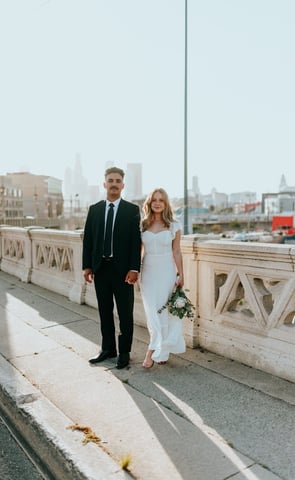 man in black suit standing beside woman in white wedding dress
