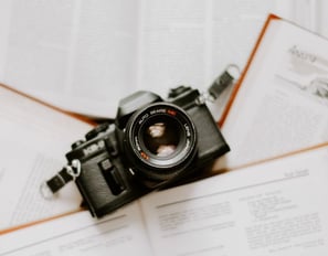 black nikon dslr camera on white printer paper