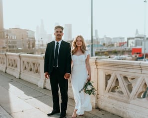 man in black suit standing beside woman in white wedding dress