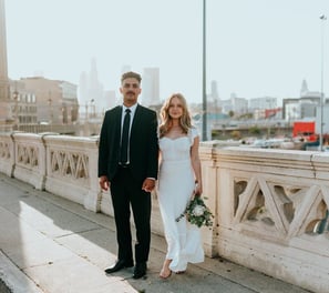 man in black suit standing beside woman in white wedding dress