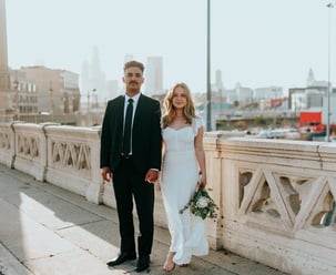 man in black suit standing beside woman in white wedding dress