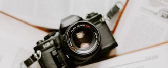 black nikon dslr camera on white printer paper