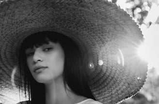 woman in white crew neck shirt wearing brown sun hat