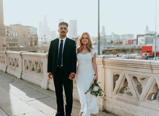 man in black suit standing beside woman in white wedding dress