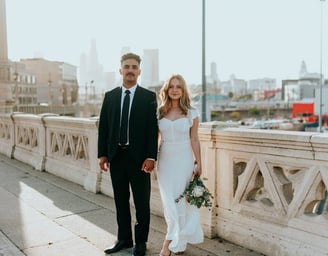 man in black suit standing beside woman in white wedding dress