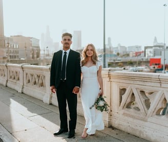 man in black suit standing beside woman in white wedding dress