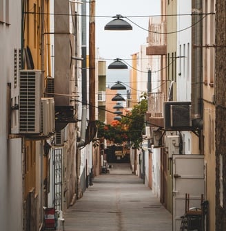 empty hallway between concrete buildings during daytime