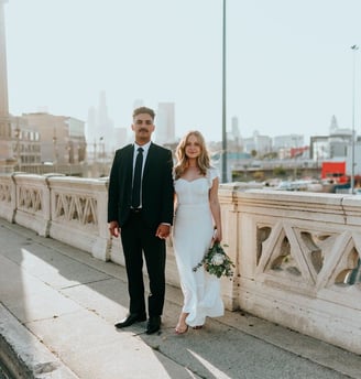 man in black suit standing beside woman in white wedding dress