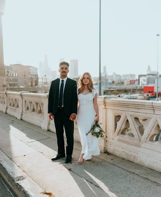 man in black suit standing beside woman in white wedding dress