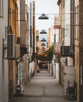 empty hallway between concrete buildings during daytime